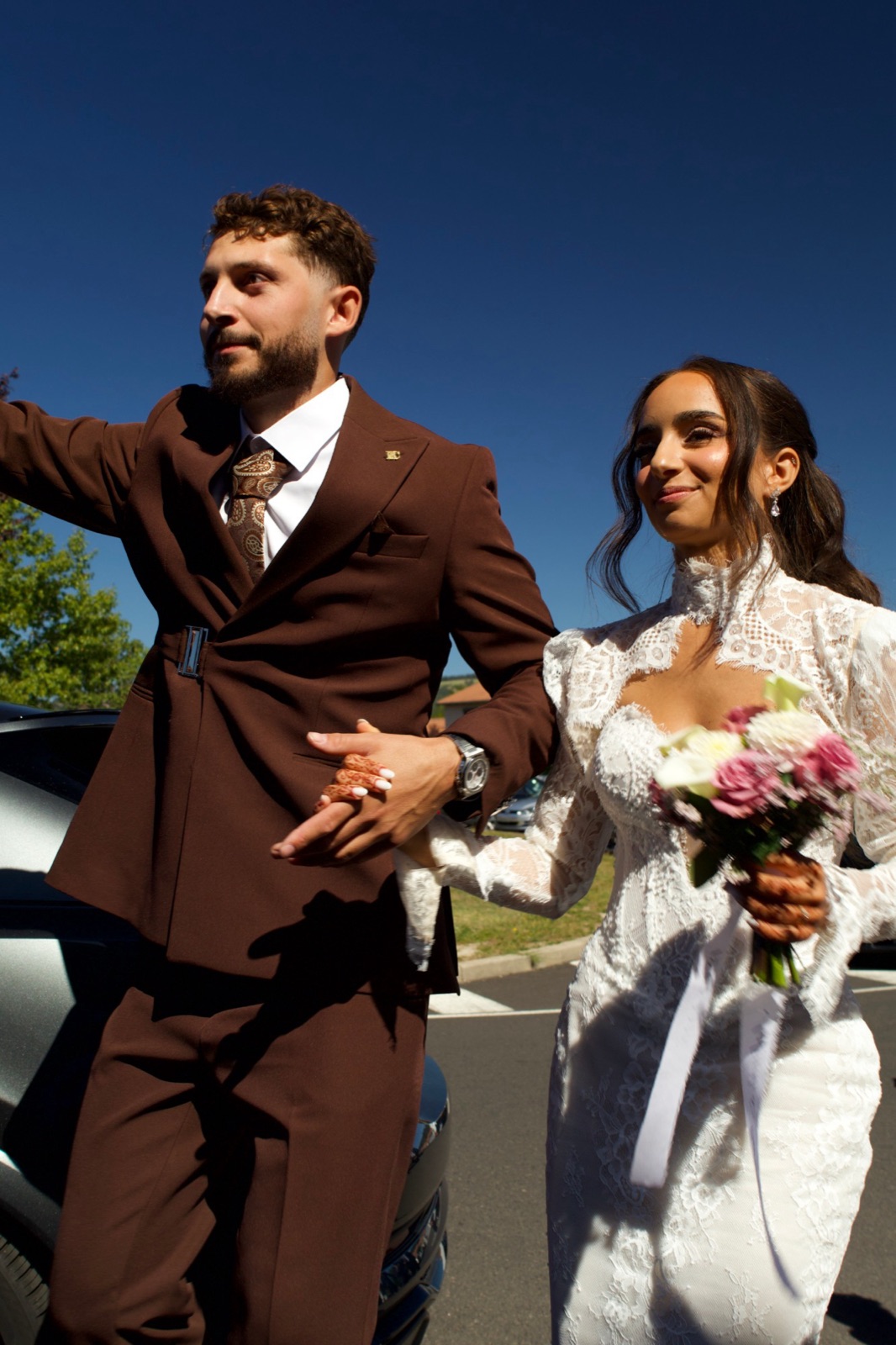 Les mariés à l'extérieur, bouquet à la main