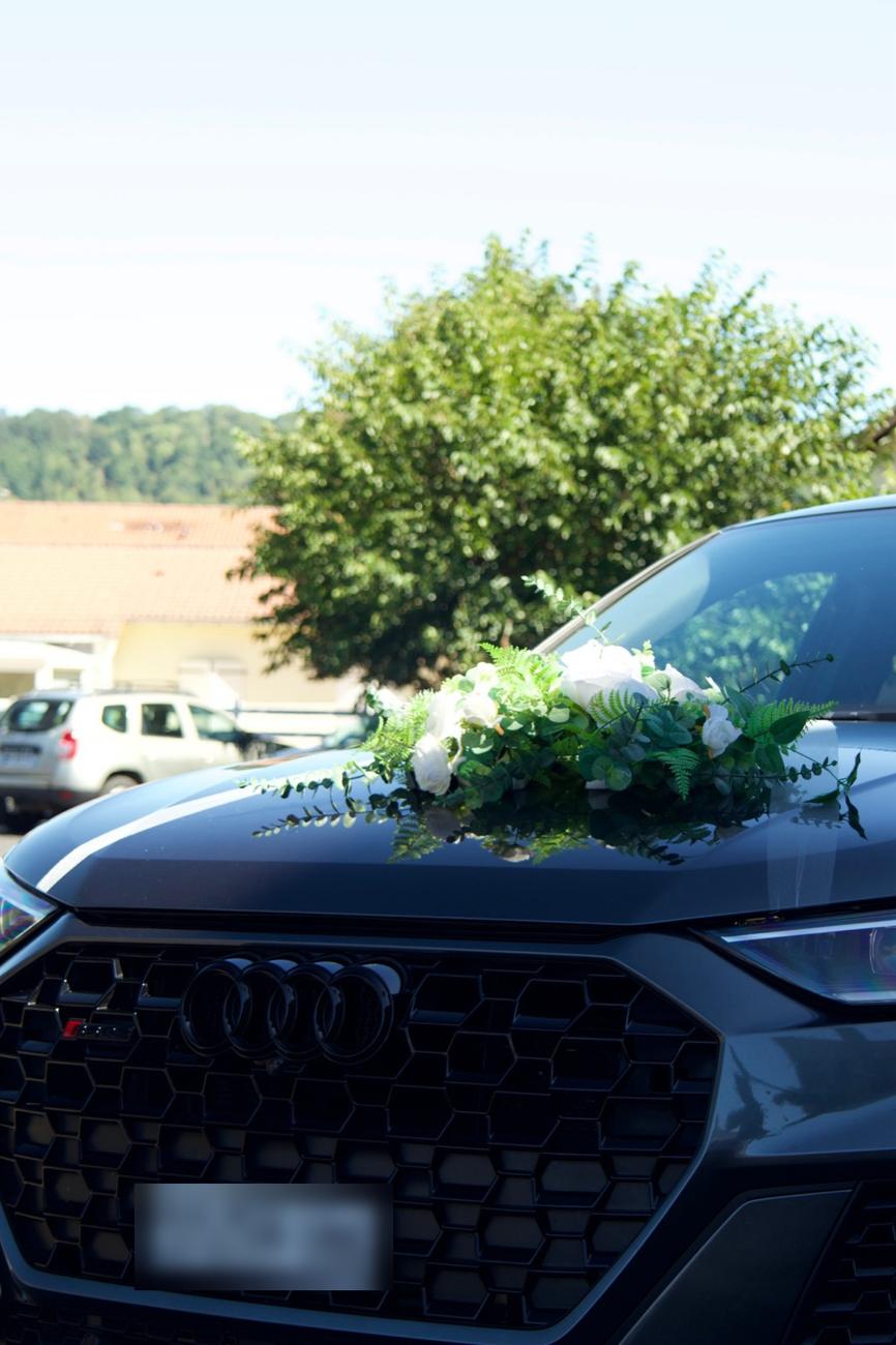 Voiture des mariés décorée de roses blanches